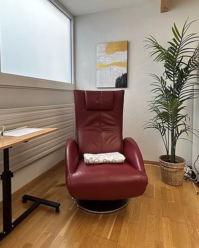 Le fauteuil du cabinet d'hypnose au Sarine Center, dans un coin calme et chaleureux, entre une plante et la lumière du jour